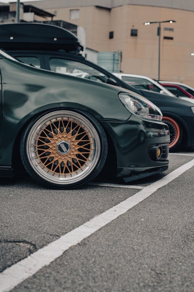 Close-up of a modified car with custom wheels parked in an urban setting.