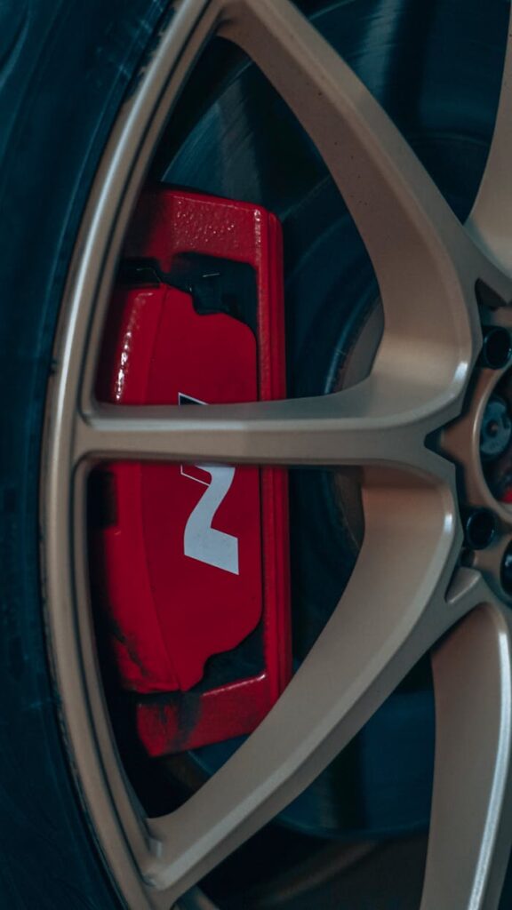 Detailed view of a red brake caliper with tire and rim for automotive enthusiasts.