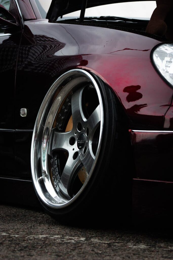 Close-up of a custom alloy wheel on a dark sports car in Almaty, Kazakhstan.