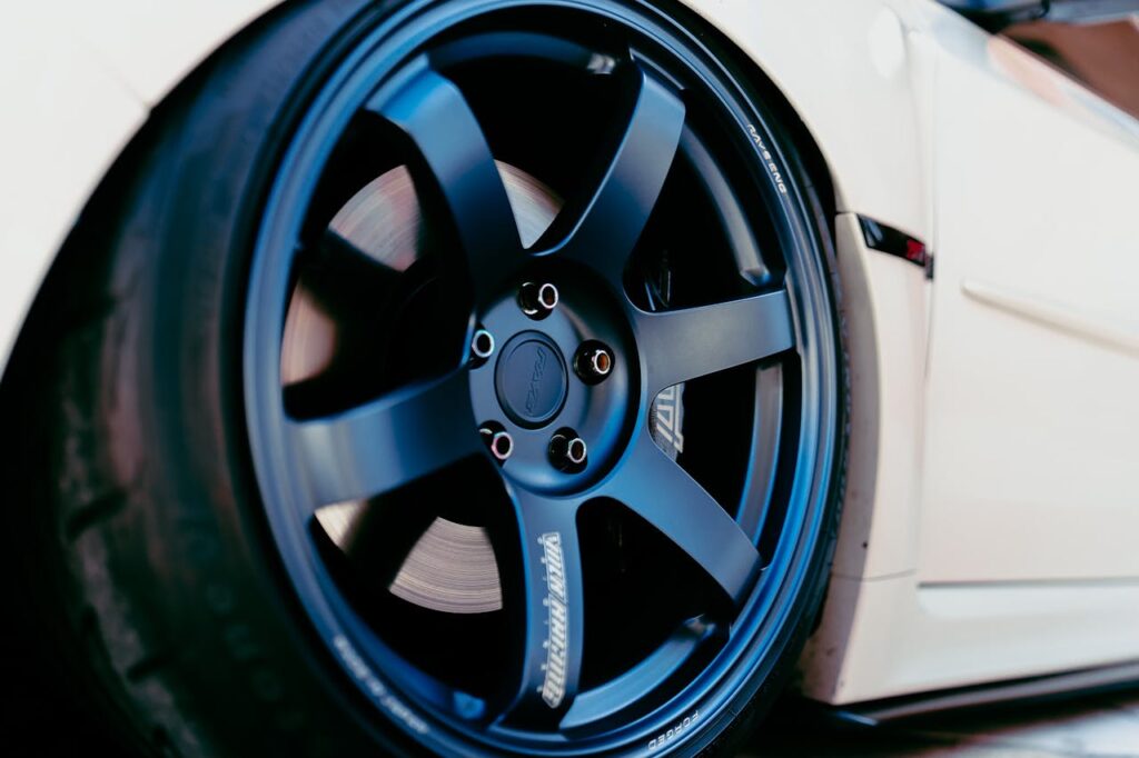 Detailed shot of a sleek vehicle's black rim and tire showcasing modern design.
