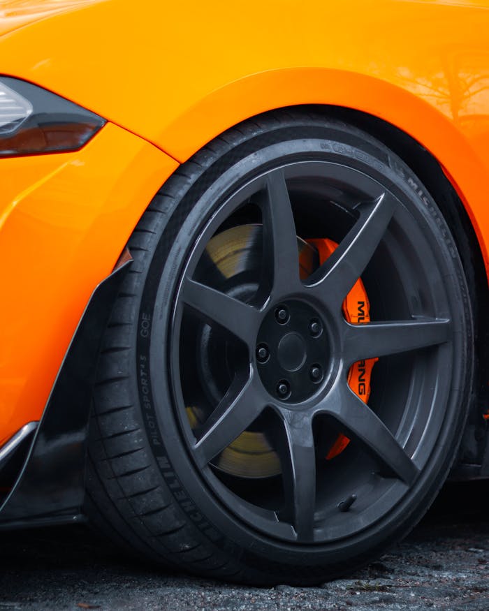 Detailed shot of a modified orange Mustang wheel with black rims in Sapanca, Türkiye.